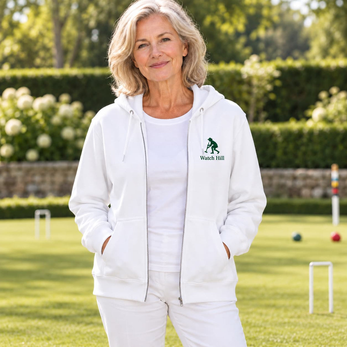 A woman  wearing a white zip-up hoodie with a green  croquet logo on the left chest