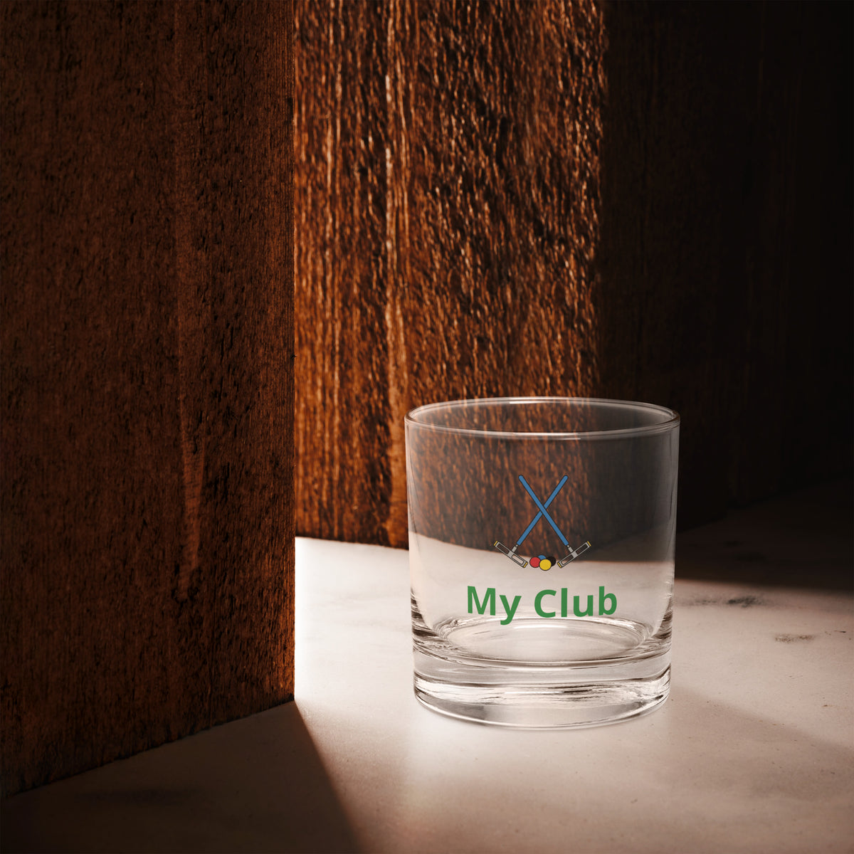 rocks glass with a croquet logo
