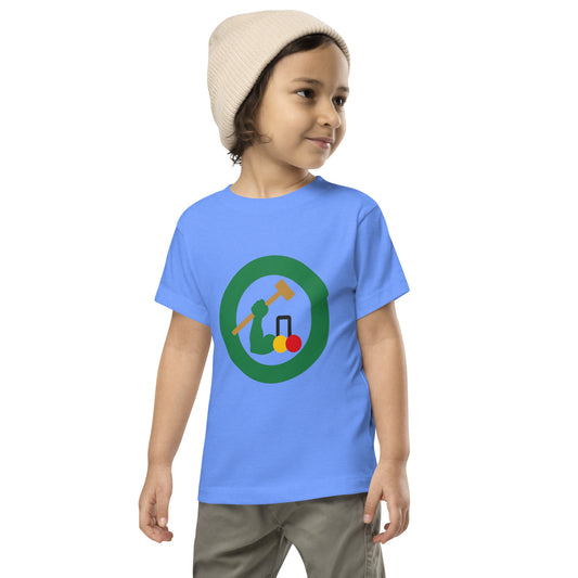 A toddler wearing a light blue t-shirt with a circular croquet mallet graphic