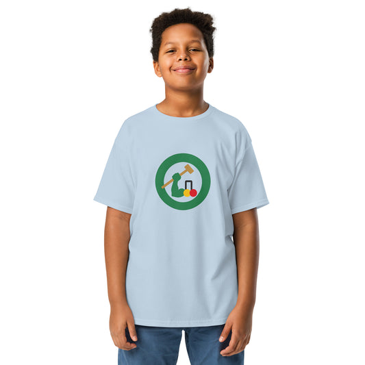 A young boy wearing a light blue crewneck t-shirt with a circular croquet graphic on the chest.